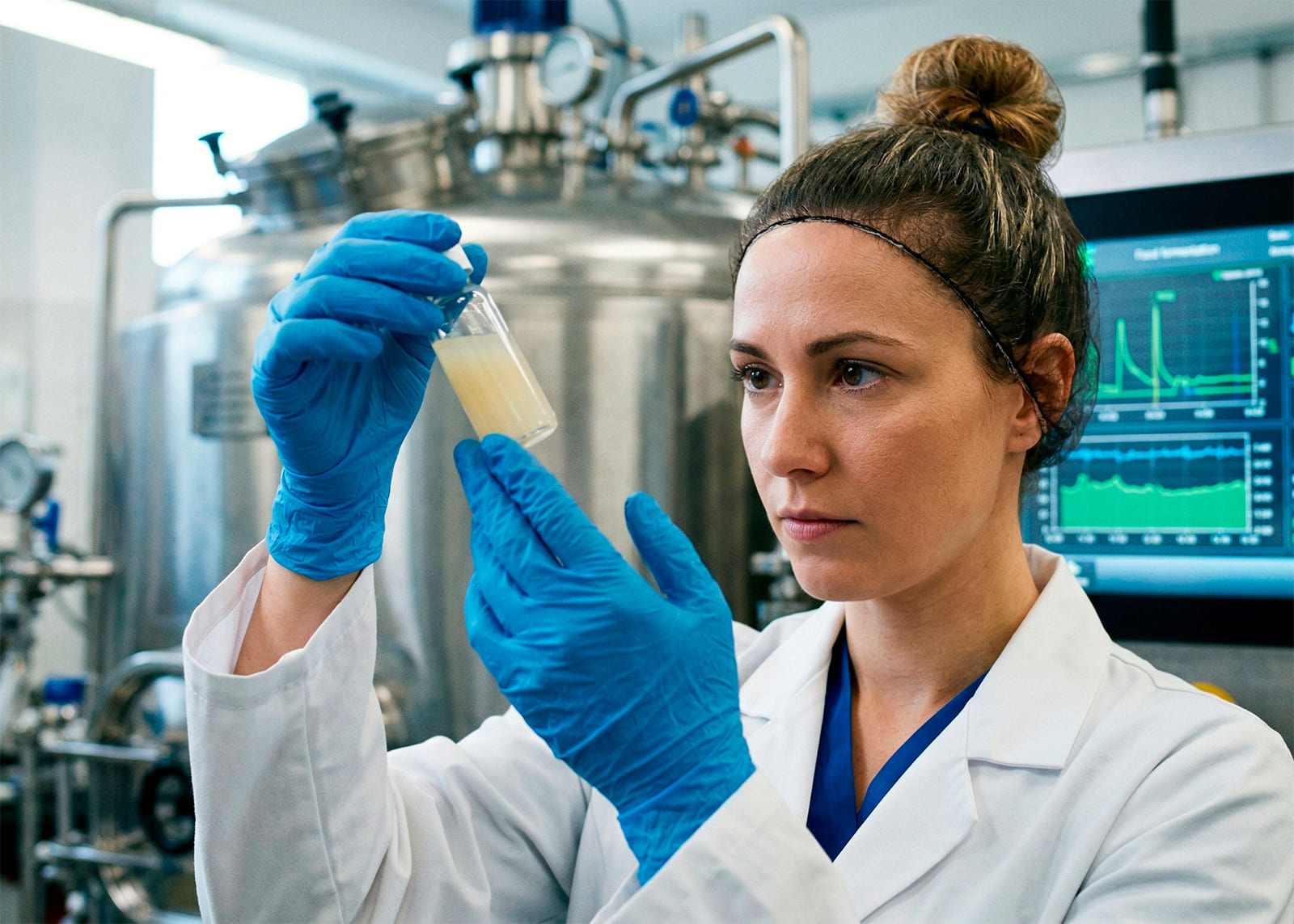 female lab specialist with a test tube at a food production facility